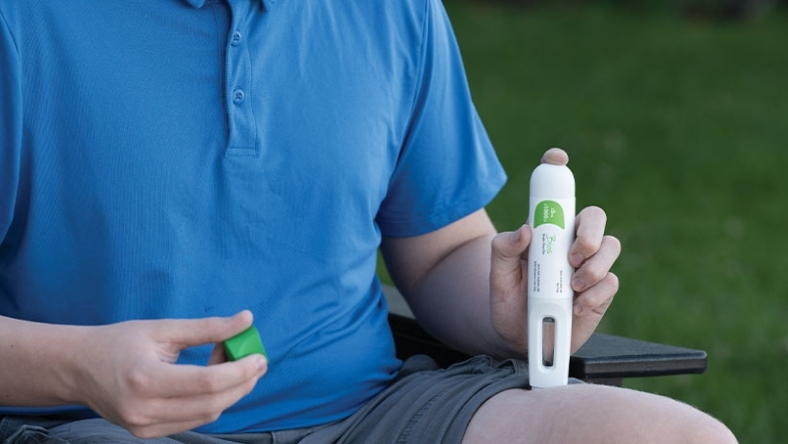 Patient holding auto-injector device for home-based drug administration