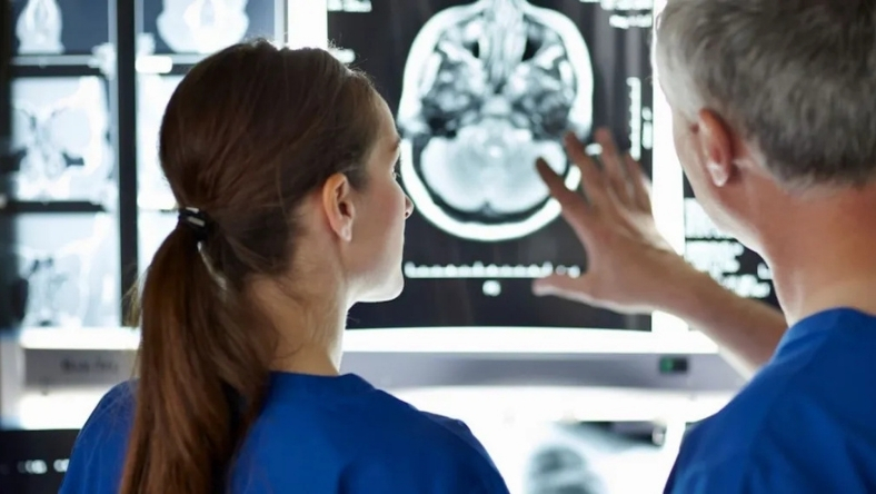 Researchers reviewing brain scan images on medical monitor in lab
